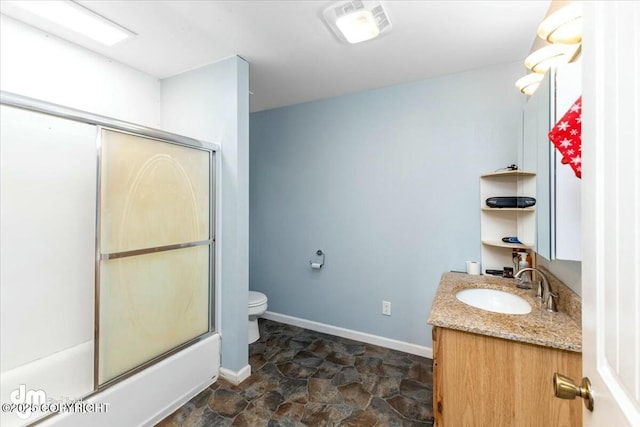 full bathroom with combined bath / shower with glass door, vanity, and toilet