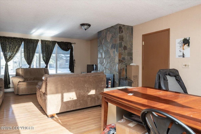 living area with light wood-style floors and a textured ceiling