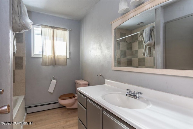 bathroom with vanity, baseboard heating, wood finished floors, and toilet