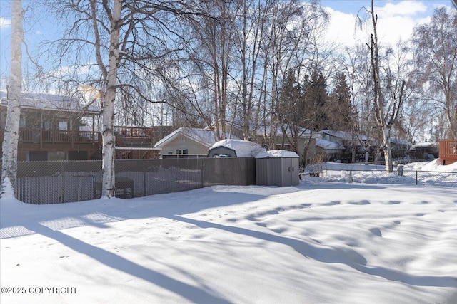 yard layered in snow with a fenced front yard