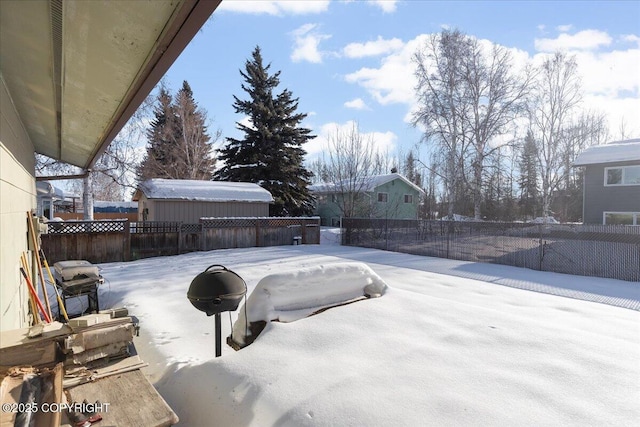 yard layered in snow with a fenced backyard