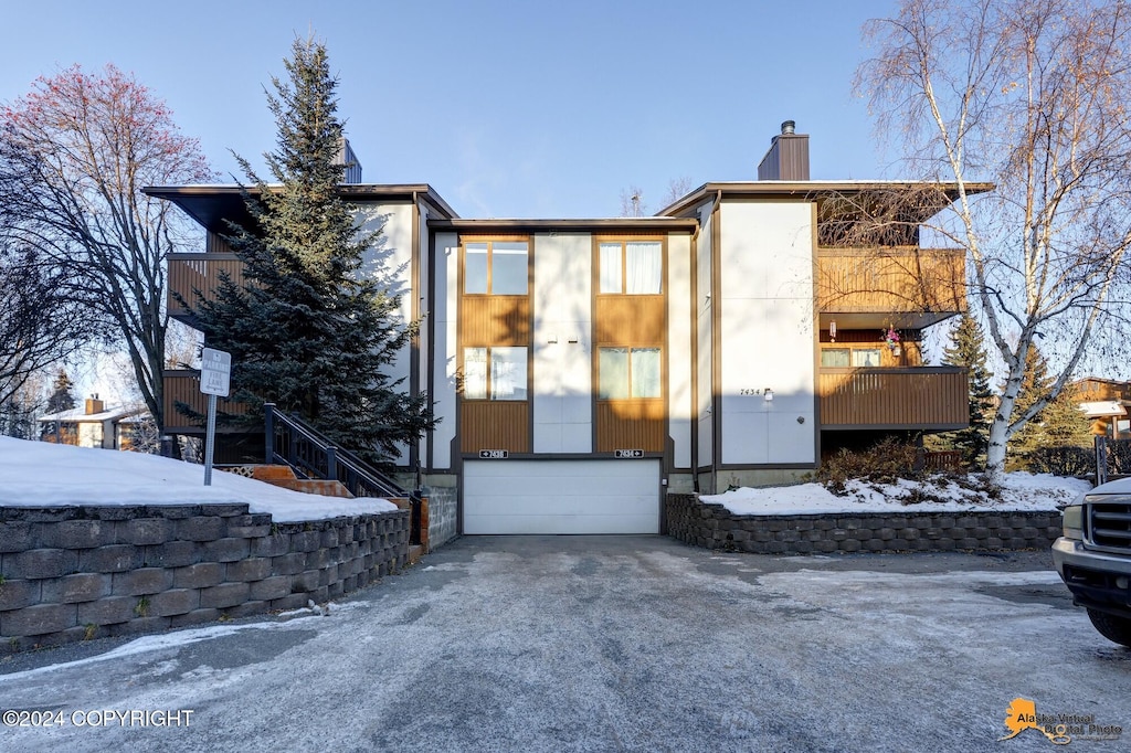 exterior space with a garage, driveway, and a chimney