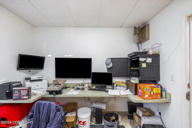 office space with a drop ceiling and built in desk