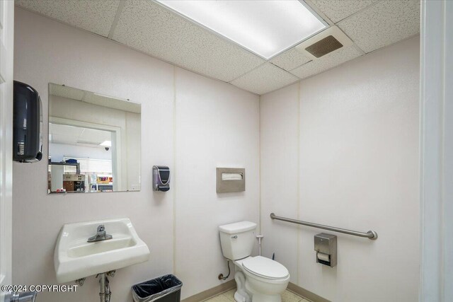 3462 S Big Lake Rd, Big Lake, AK 99623 - half bathroom featuring a paneled ceiling, a sink, toilet, and baseboards