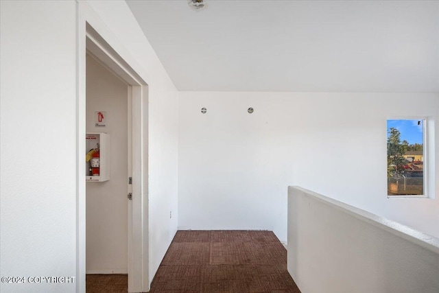 corridor featuring dark colored carpet