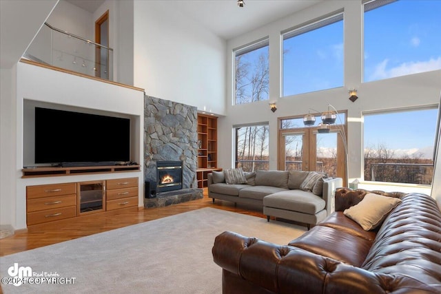 living room with hardwood / wood-style flooring, a healthy amount of sunlight, and a towering ceiling