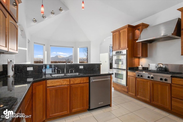 kitchen with appliances with stainless steel finishes, sink, wall chimney range hood, decorative light fixtures, and light tile patterned flooring