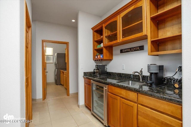 kitchen featuring dark stone countertops, light tile patterned floors, sink, and wine cooler