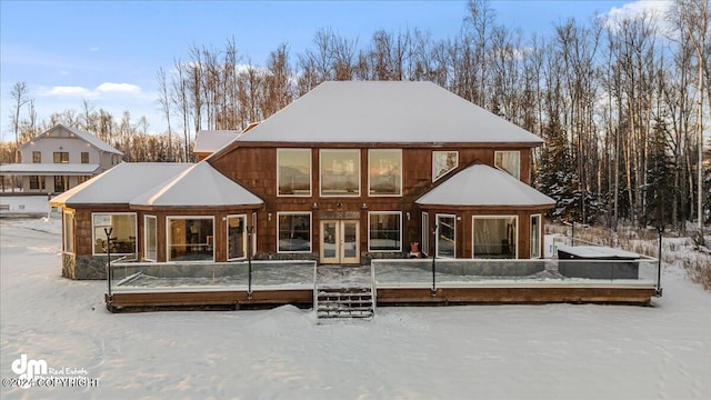 snow covered back of property with french doors