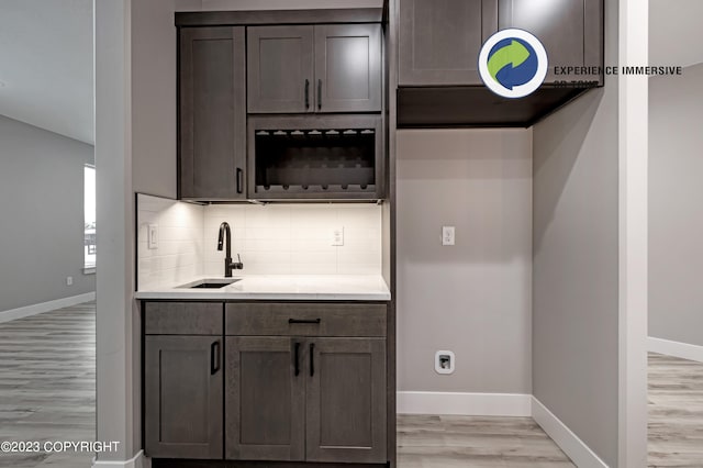 kitchen with dark brown cabinetry, light hardwood / wood-style floors, and sink