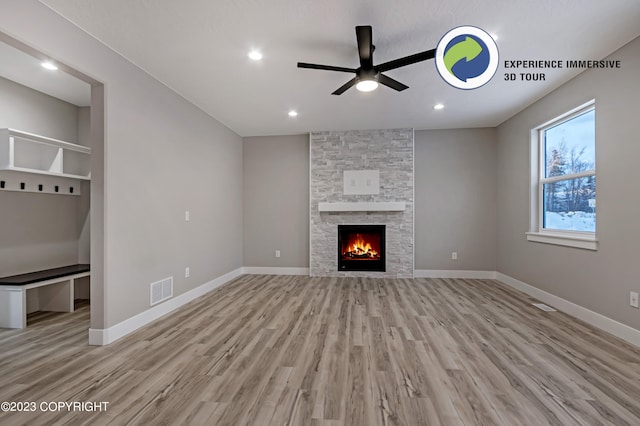 unfurnished living room featuring ceiling fan, a fireplace, and light hardwood / wood-style floors