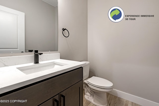 bathroom with hardwood / wood-style floors, vanity, and toilet