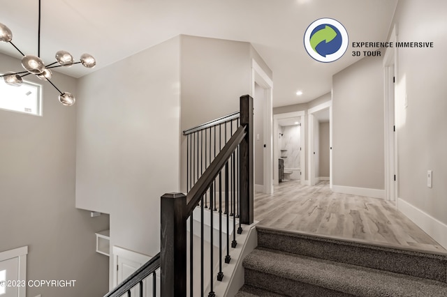 stairs featuring hardwood / wood-style flooring and a notable chandelier