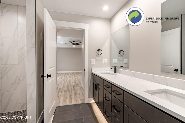 bathroom with a tile shower, ceiling fan, and vanity