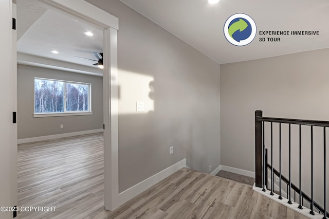 stairs featuring wood-type flooring and ceiling fan