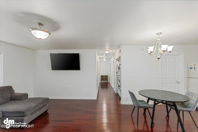 dining area with an inviting chandelier and dark wood-type flooring