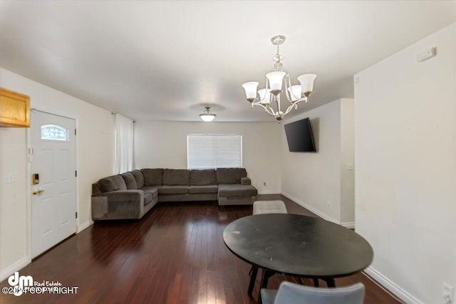 living room featuring dark wood-type flooring and a notable chandelier