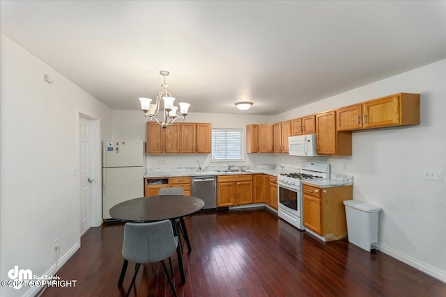 kitchen featuring sink, dark wood-type flooring, a chandelier, decorative light fixtures, and white appliances