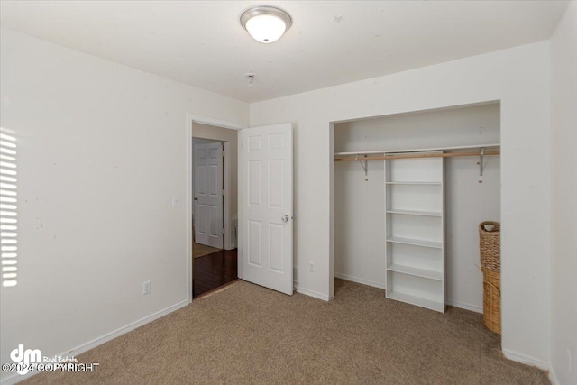 unfurnished bedroom featuring light colored carpet and a closet