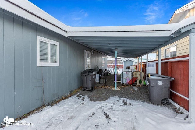 snow covered patio with a carport