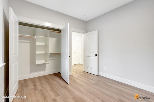 unfurnished bedroom with a closet and light hardwood / wood-style flooring