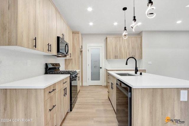 kitchen with sink, light brown cabinets, hanging light fixtures, and black appliances