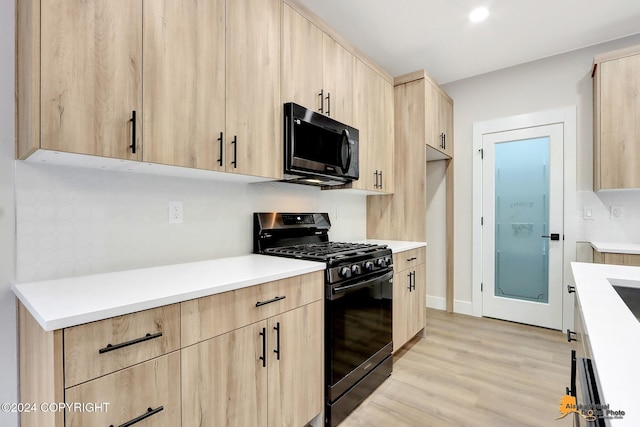 kitchen featuring light hardwood / wood-style floors, light brown cabinets, and black appliances