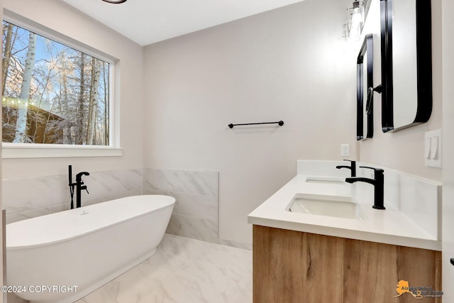 bathroom with tile walls, a washtub, and vanity