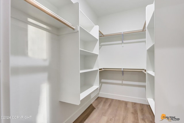 walk in closet with light hardwood / wood-style floors