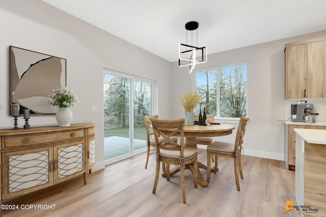 dining space with a chandelier, light hardwood / wood-style floors, and plenty of natural light