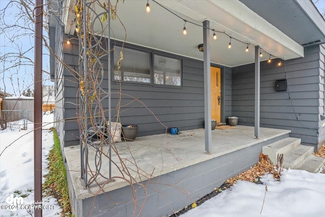 snow covered patio featuring covered porch