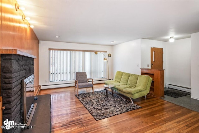 living room with a fireplace, a baseboard radiator, and hardwood / wood-style flooring