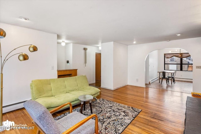 living room with wood-type flooring and a baseboard heating unit