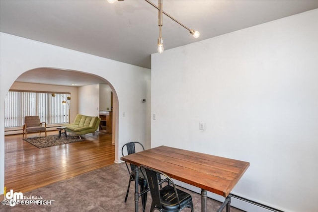 dining room with hardwood / wood-style flooring and a baseboard heating unit