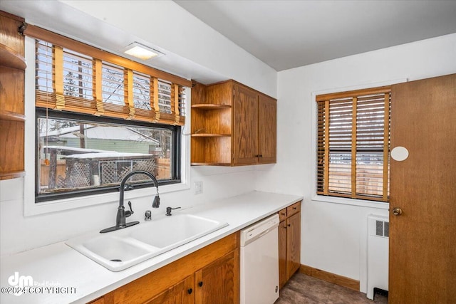 kitchen featuring sink, white dishwasher, and radiator