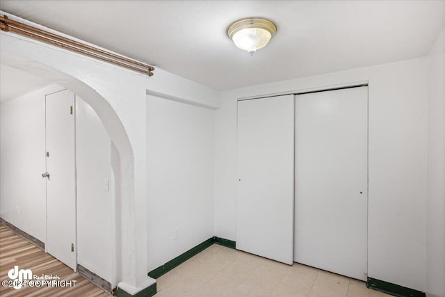 unfurnished bedroom featuring light wood-type flooring and a closet