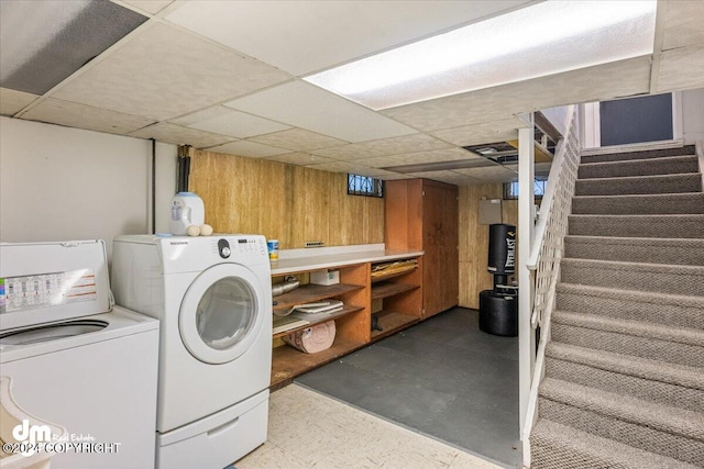 clothes washing area with independent washer and dryer and wooden walls