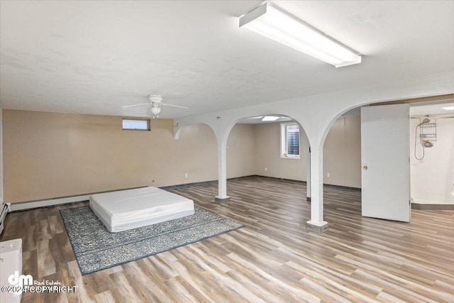 basement with ceiling fan and light hardwood / wood-style floors