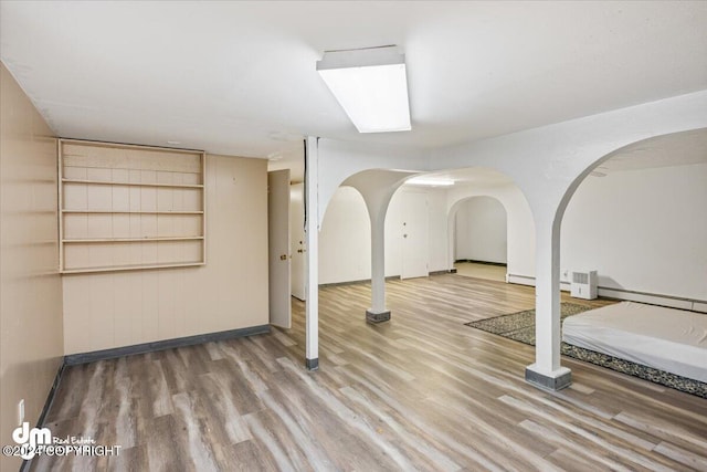 interior space with a baseboard heating unit and hardwood / wood-style flooring