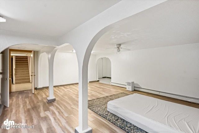 interior space featuring baseboard heating, ceiling fan, and hardwood / wood-style floors