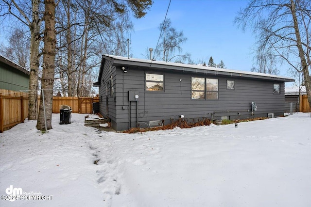 view of snow covered rear of property