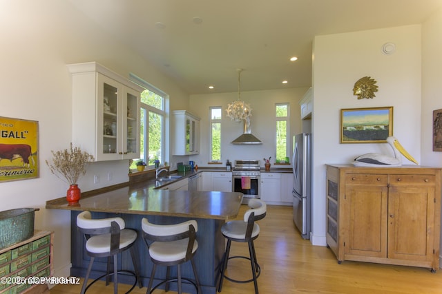 4760 Craftsman Rd, Homer, AK 99603 - kitchen with appliances with stainless steel finishes, a sink, a peninsula, dark countertops, and light wood-style floors