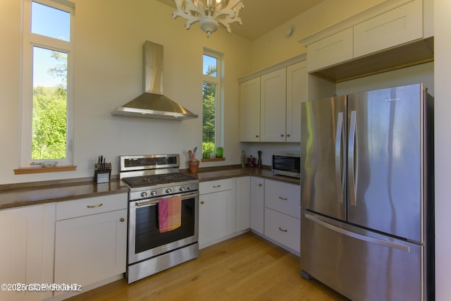 4760 Craftsman Rd, Homer, AK 99603 - kitchen with appliances with stainless steel finishes, wall chimney range hood, healthy amount of natural light, and a chandelier