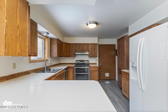 kitchen featuring dark hardwood / wood-style flooring, kitchen peninsula, sink, and appliances with stainless steel finishes