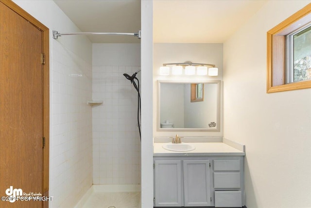 bathroom with vanity and tiled shower