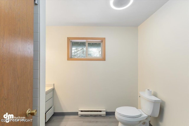 bathroom featuring hardwood / wood-style flooring, vanity, toilet, and baseboard heating