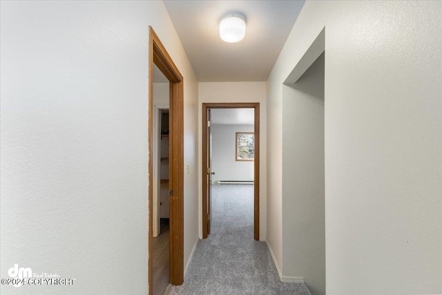 hallway featuring light colored carpet and a baseboard heating unit