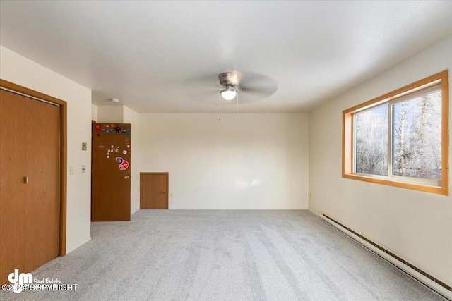 unfurnished room with carpet flooring, baseboard heating, and ceiling fan