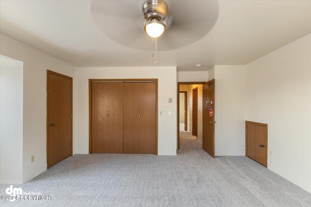 unfurnished bedroom featuring light colored carpet and ceiling fan