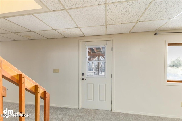 entryway with a drop ceiling and carpet